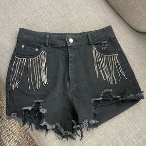 Black jean shorts with silver diamond tassels.